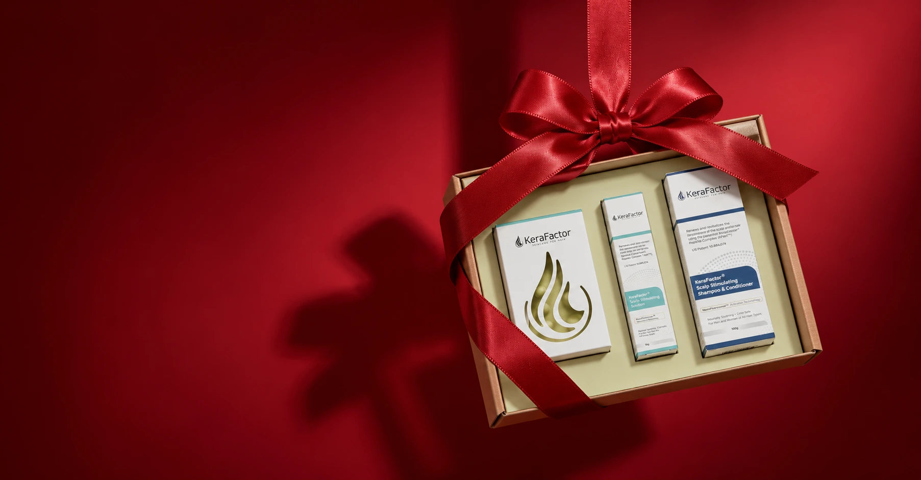 KeraFactor hair care products in a gift box tied with a red holiday ribbon